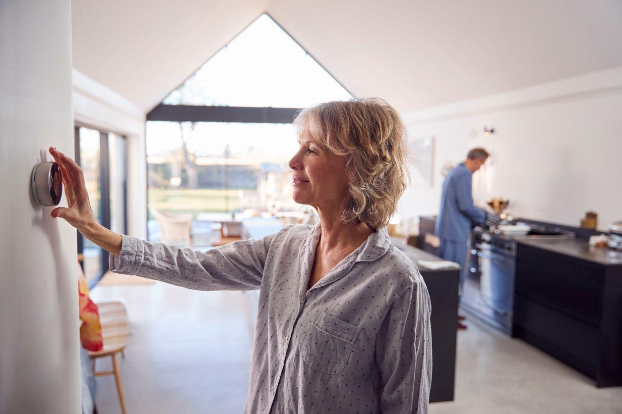 Woman adjusting the thermostat