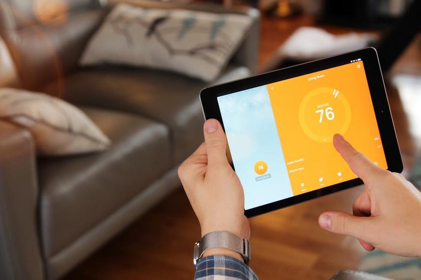 Homeowner using smart tablet to control air conditioner