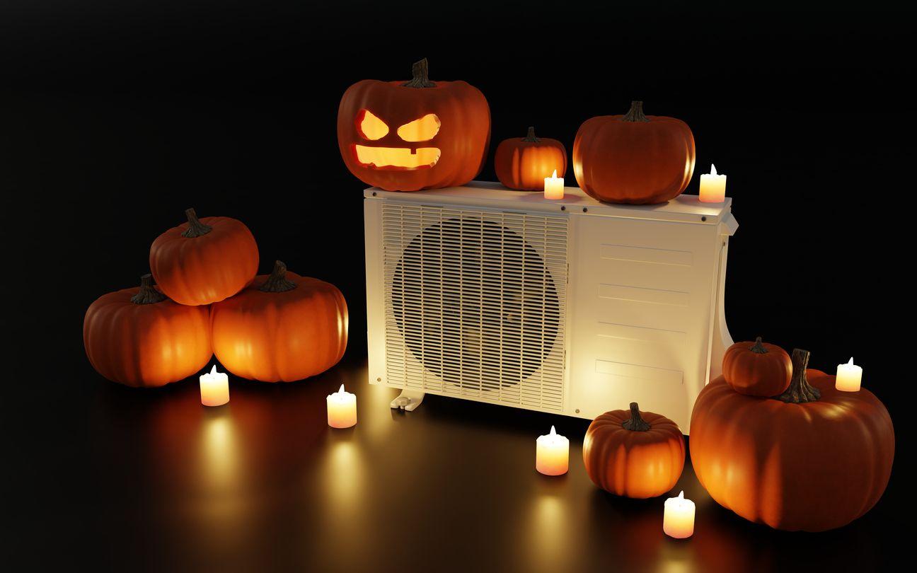 Multiple pumpkins around an HVAC unit