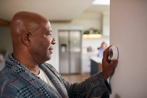 Man adjusting thermostat