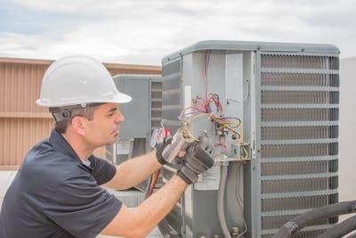 HVAC contractor repairing air conditioner