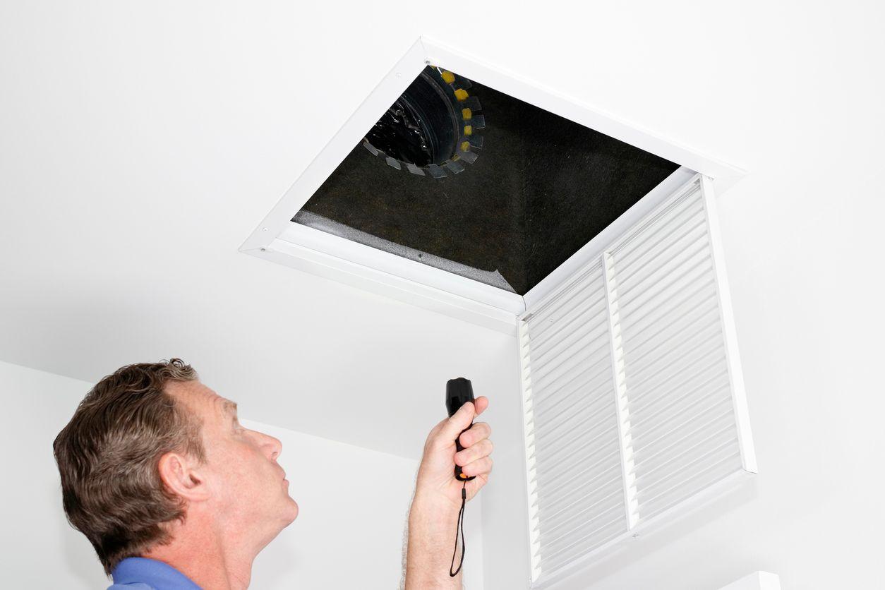 HVAC technician inspecting air ducts
