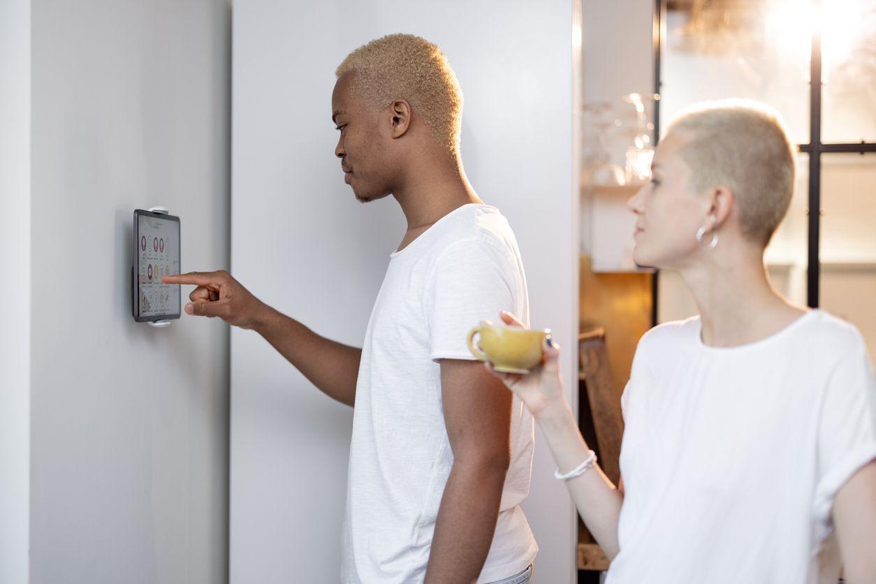 Couple adjusting their thermostat