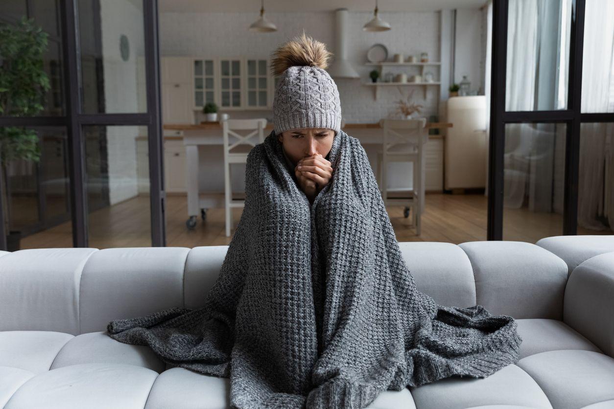 Woman bundled up inside to stay warm
