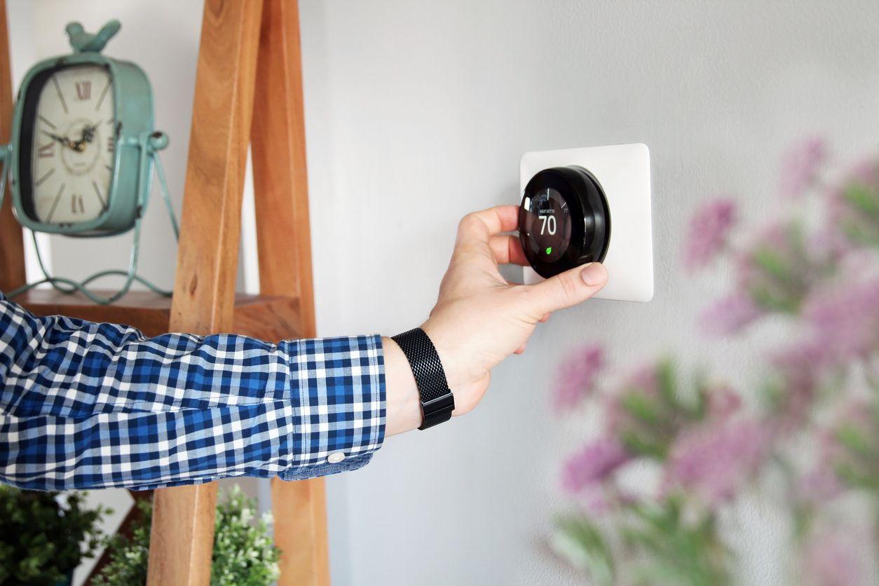 Man adjusting a smart thermostat