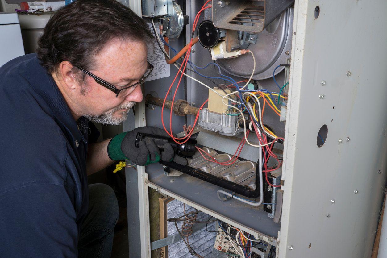 HVAC technician inspecting furnace