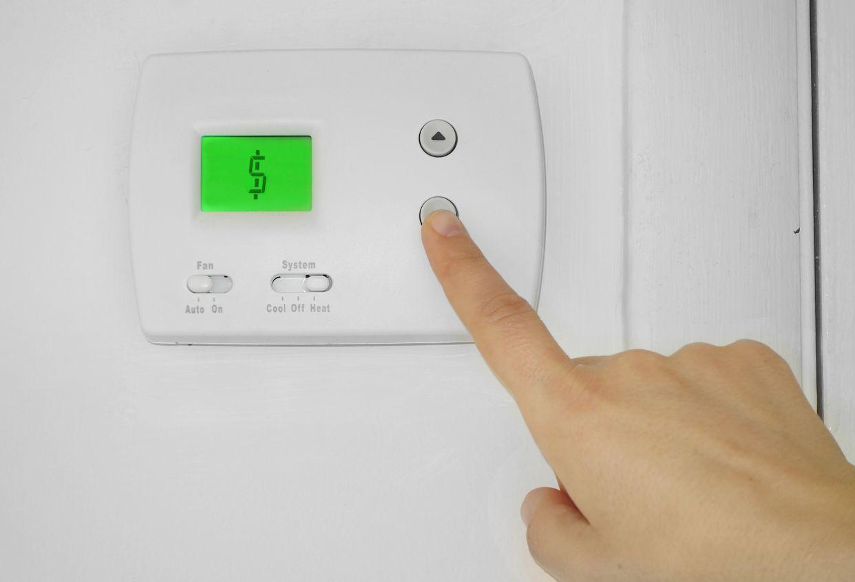 Homeowner adjusting thermostat