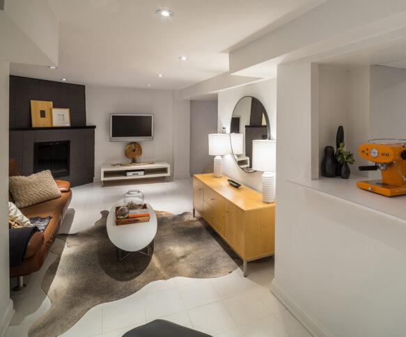 Interior of modern home residence in Canada. Open concept of basement level with modern furniture and entertainment.