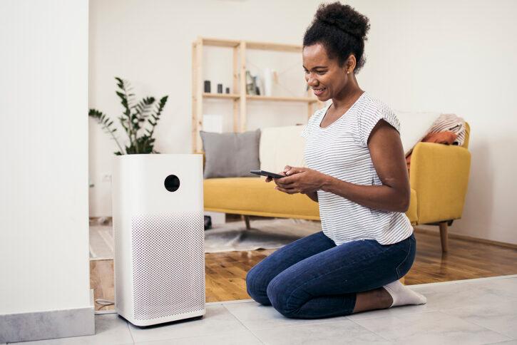 African American woman setting up the intelligent home system on a smartphone.