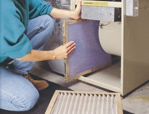 person changing air filter on hvac system