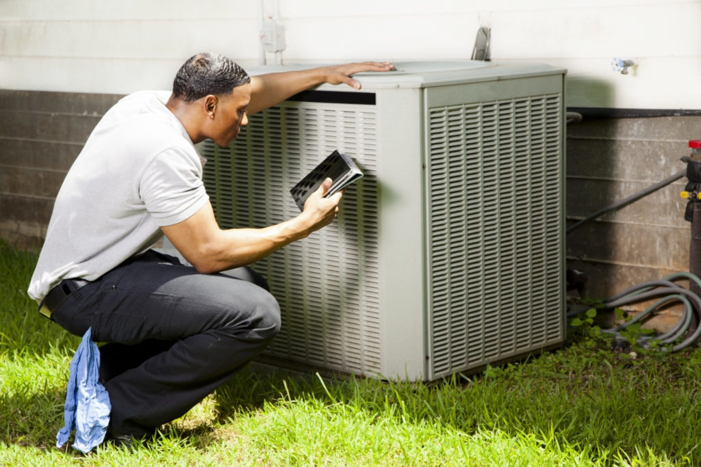 man checks hvac unit for repair