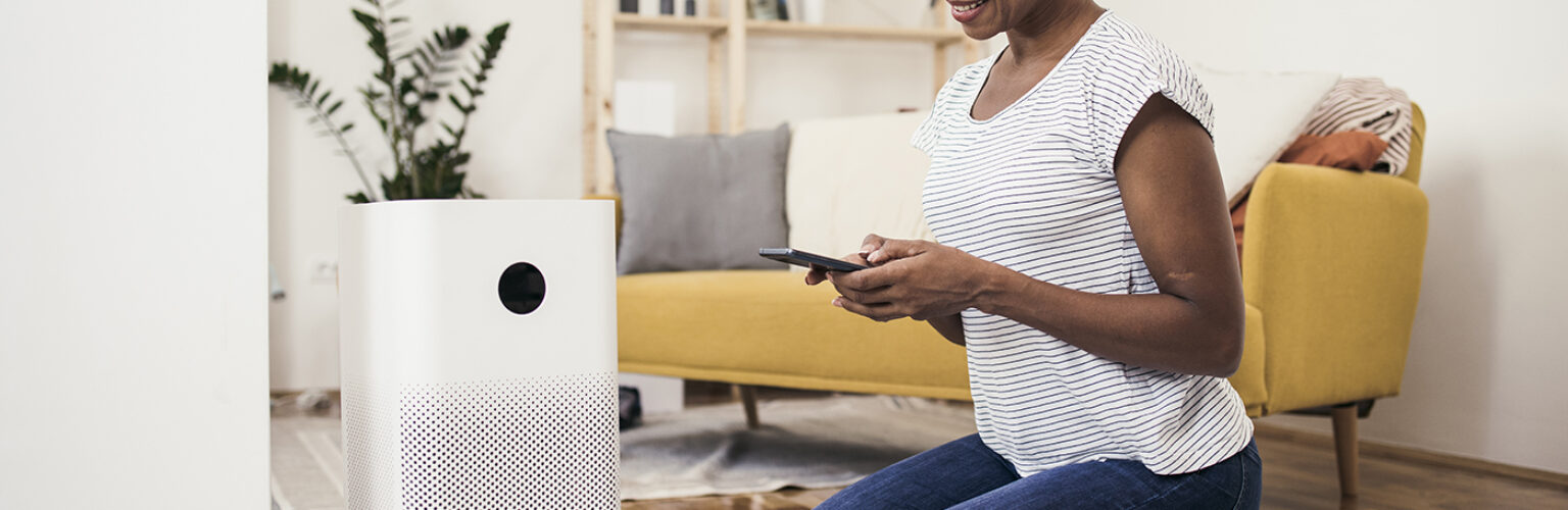 person adjusting their air purifier on their phone