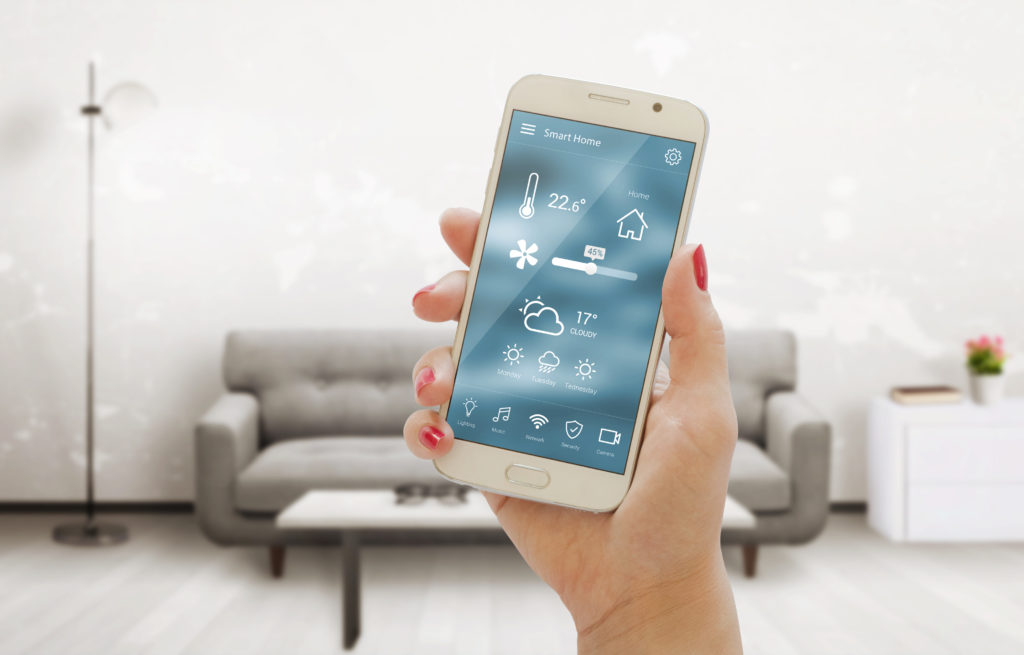 hand holding smartphone with thermostat app in living room