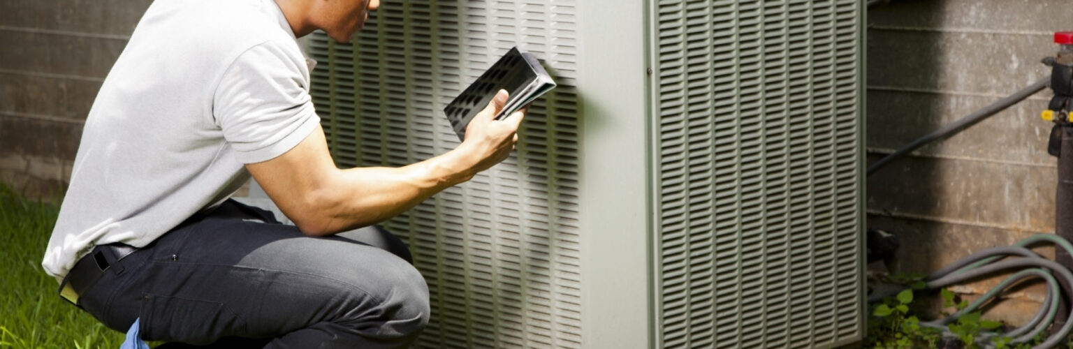 man checks hvac unit for repair