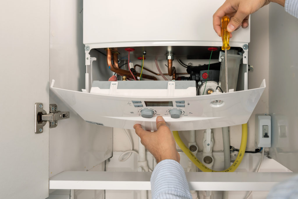 hands repairing combi gas boiler