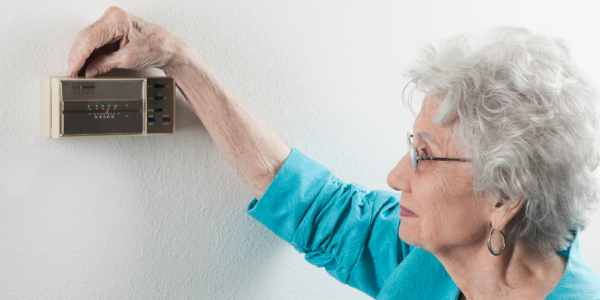 person changing their thermostat