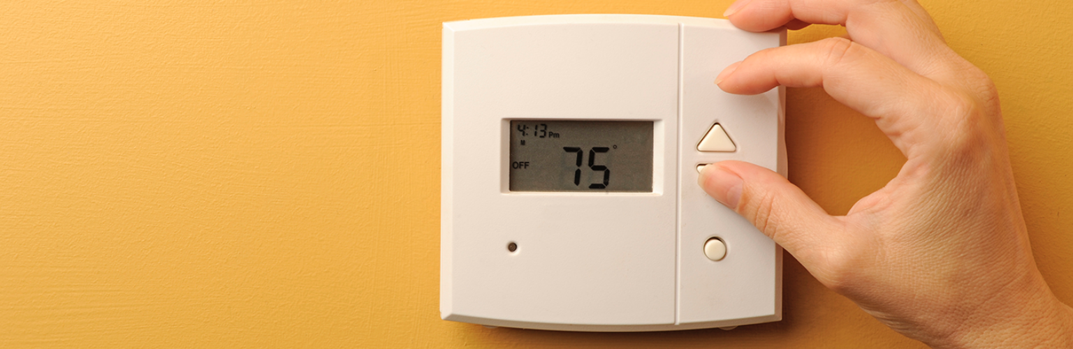 woman-adjusting-thermostat