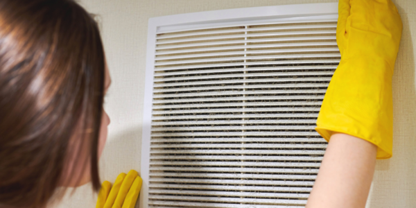 person cleaning air vent