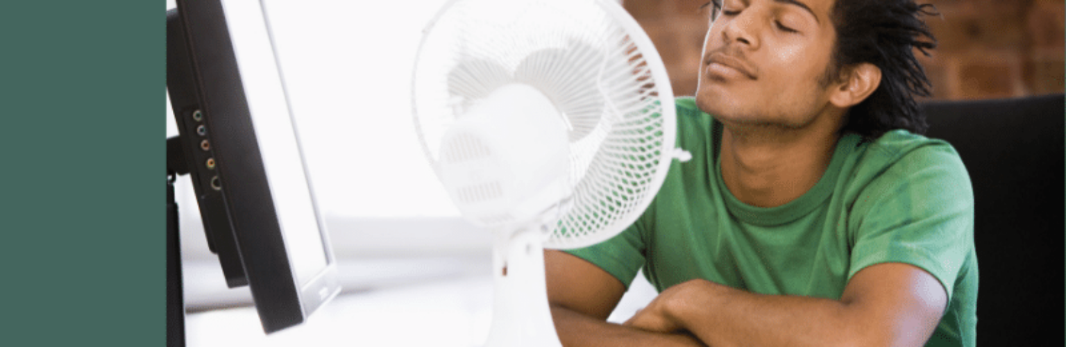 man sitting in front of fan