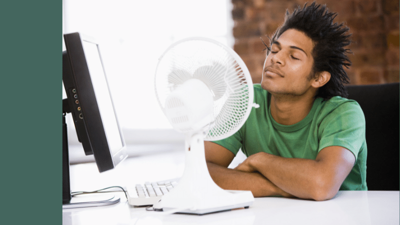 man sitting in front of fan