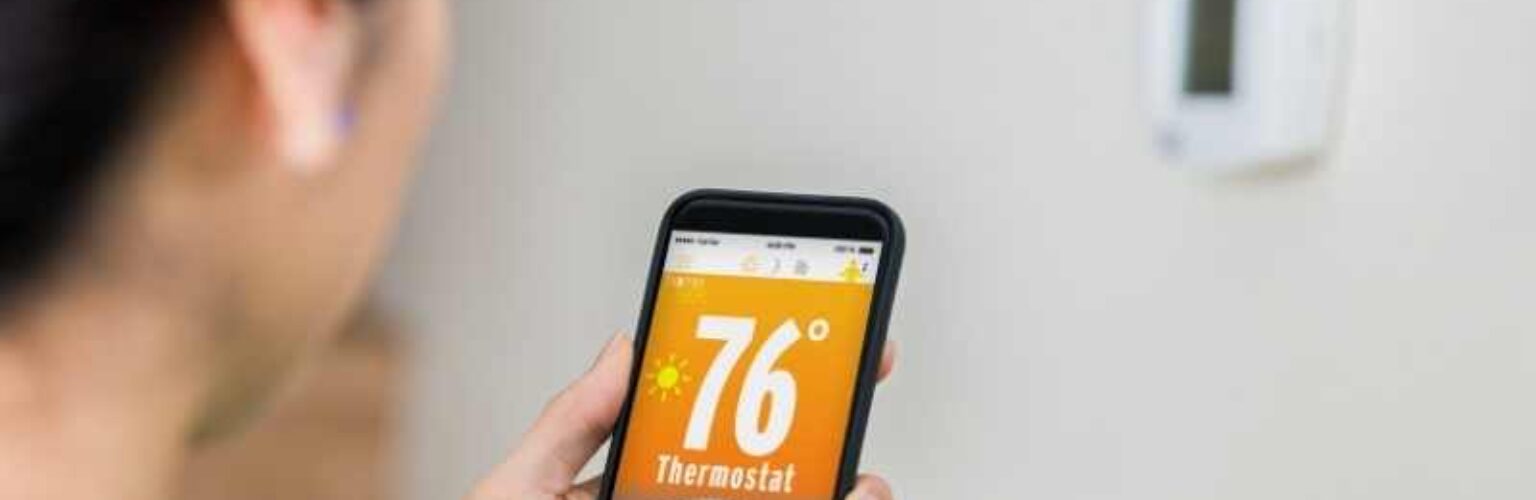 woman controlling wireless thermostat
