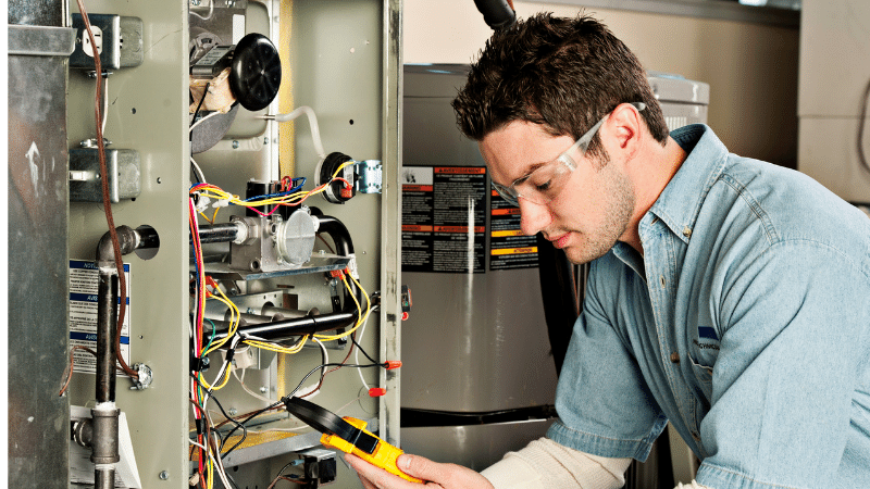 repairman looking at furnace