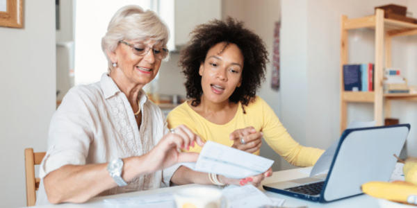 women paying bills at kitchen table