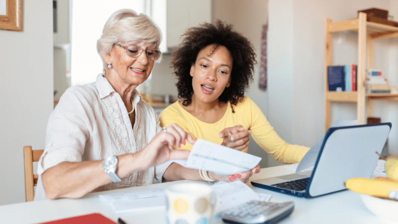 women paying bills at kitchen table