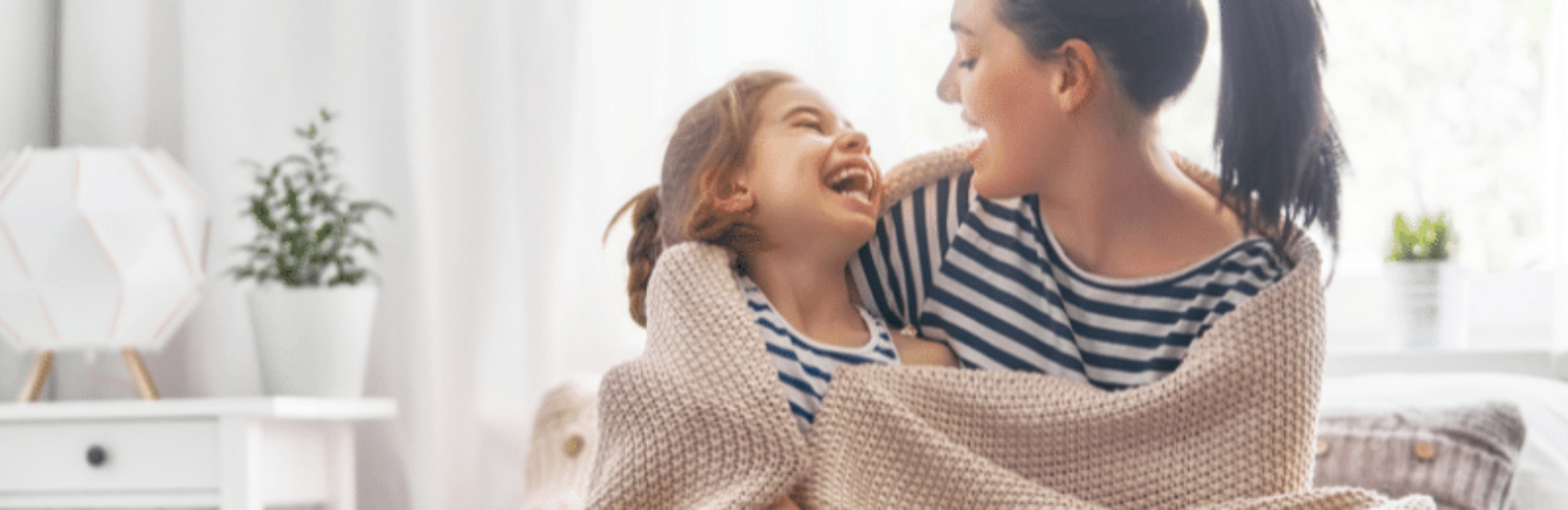woman and daughter snuggling in blanket
