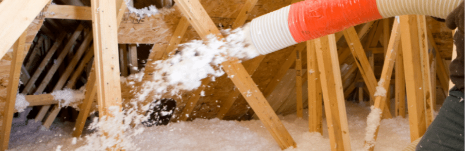 contractor blowing in insulation in attic