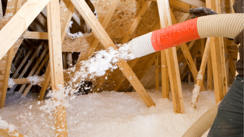 contractor blowing in insulation in attic